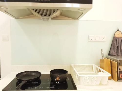 a kitchen with two pots on a stove top at Skypod Residence Puchong in Puchong