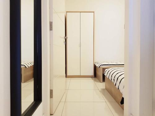 a hallway with two beds and a door to a room at Skypod Residence Puchong in Puchong