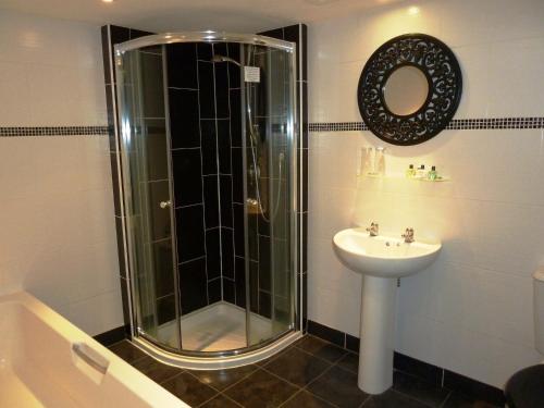 ein Bad mit einer Dusche und einem Waschbecken in der Unterkunft The Manor House Hotel in Dronfield