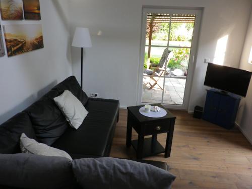 uma sala de estar com um sofá e uma mesa em Echt Ostfriesenhus em Norden