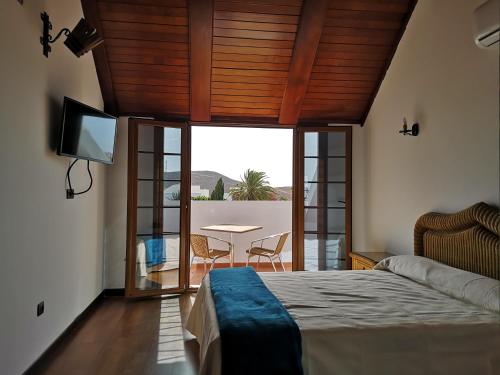 a bedroom with a bed and a table with a television at La Casona Canaria Boutique Home B & B in Agüimes