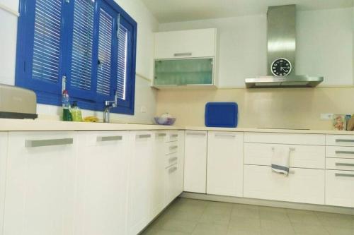 a kitchen with white cabinets and blue windows at Auténtica Casa Mediterránea con vistas al mar in Santa Pola