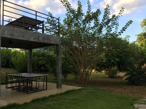 a picnic table in a garden with a tree at ชลลดา ริเวอร์ โฮมสเตย์ แก่งกระจาน in Ban Wang Malako