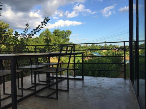 a balcony with a table and chairs and a view at ชลลดา ริเวอร์ โฮมสเตย์ แก่งกระจาน in Ban Wang Malako