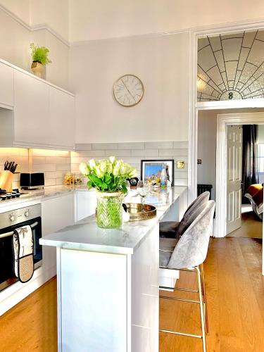 a kitchen with a counter with a vase of flowers on it at Mrs Butler Brighton Boutique by the Sea and Great Prices in Brighton & Hove