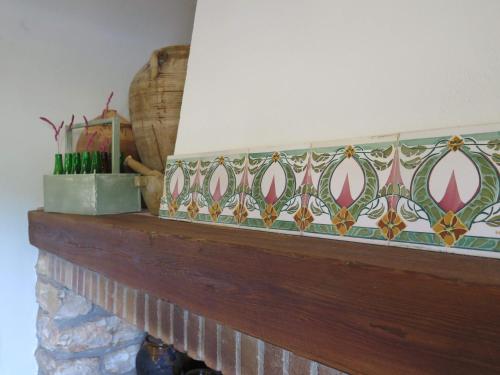 a mantle with a mosaic tile on top of it at Casa El Ros II - Turistrat in Vall dʼAlba