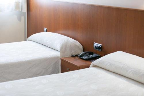 a hotel room with two beds and a telephone at Andamur San Román in San Román