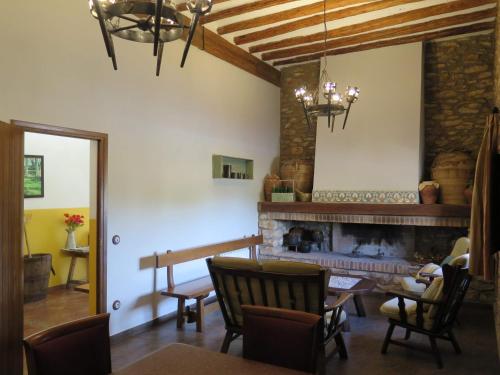 sala de estar con chimenea, mesa y sillas en Casa El Ros II - Turistrat, en Vall dʼAlba