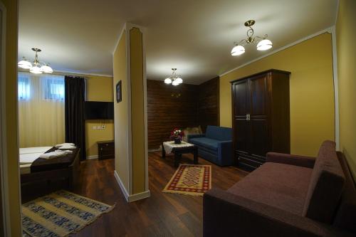 a living room with a couch and a chair at Pulpudeva Family Hotel in Plovdiv