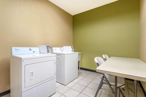 a laundry room with a washer and dryer and a table at Super 8 by Wyndham Goshen in Goshen