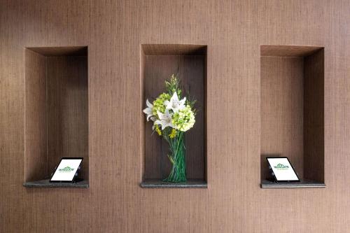 a vase of flowers on a wall with two signs at Wingate by Wyndham - St. George in St. George