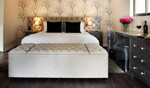 a bedroom with a large bed with a tufted headboard at Alluvia Boutique Winery & Luxury Accommodation in Stellenbosch