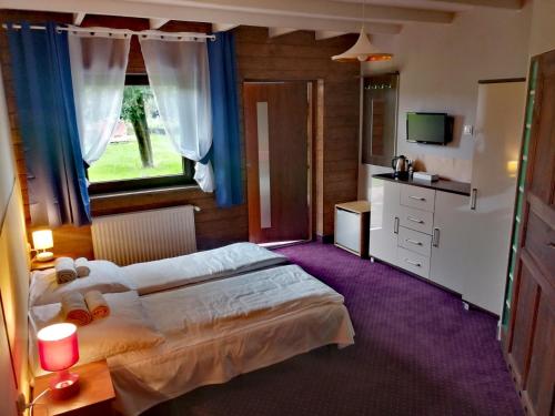 1 dormitorio con 2 camas y ventana en Hotel Zasieki, en Zasieki