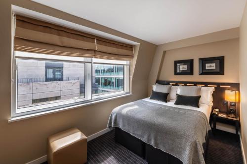 a bedroom with a bed and a window at The Resident Victoria in London