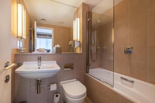 a bathroom with a toilet and a sink and a shower at The Resident Victoria in London