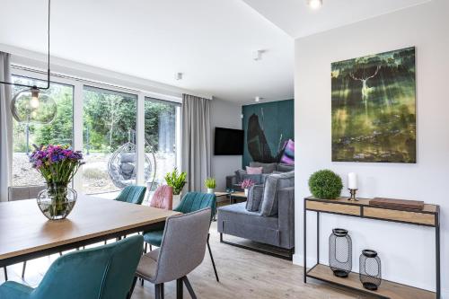 a dining room and living room with a table and chairs at Śnieżka Exclusive Apartamenty in Kowary