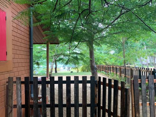 a wooden fence in front of a building at Natura luxury red house in Ouidah