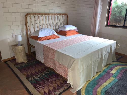 a bedroom with a large bed with pillows on it at Natura luxury red house in Ouidah