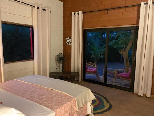 um quarto com uma cama e uma grande janela em Natura luxury red house em Ouidah