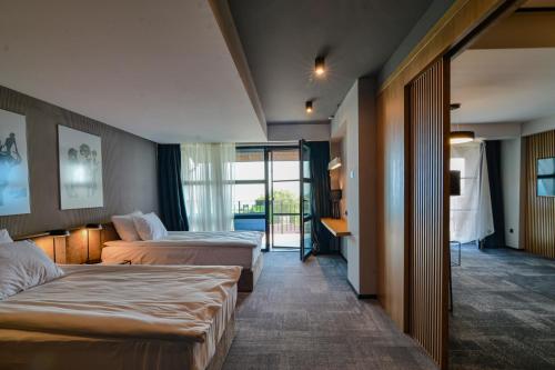 a hotel room with two beds and a balcony at Hotel Boutique by BlackSeaRama, a Small Luxury Hotels of the World member in Balchik