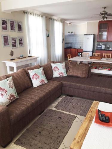 a living room with a brown couch and a kitchen at Arabella No. 8 in Margate