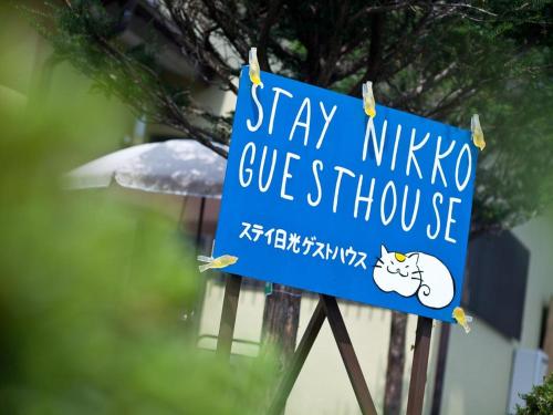um sinal azul com um gato em Stay Nikko Guesthouse em Nikko