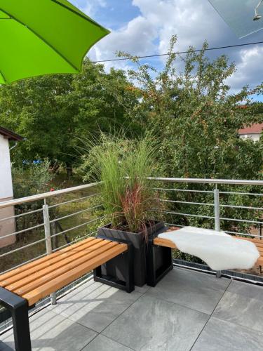 a bench and a chair on a balcony at Bauernhaus Loth - exklusive Ferienwohnungen in Mitlosheim