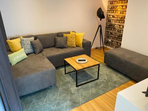 a living room with a couch and a table at Bauernhaus Loth - exklusive Ferienwohnungen in Mitlosheim
