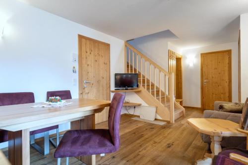a living room with a dining room table with purple chairs at Gästehaus Rass in Lofer