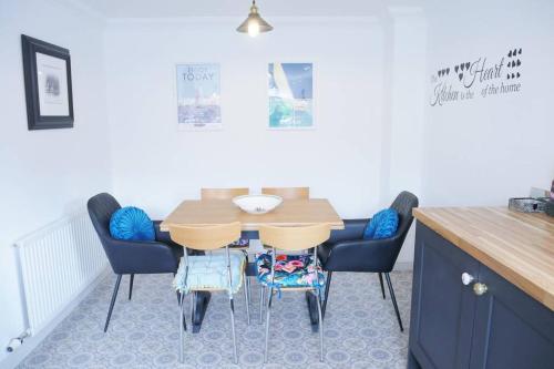 a kitchen with a wooden table and chairs at The Croft a lovely town house in the centre of Holt with free PARKING for two cars in Holt