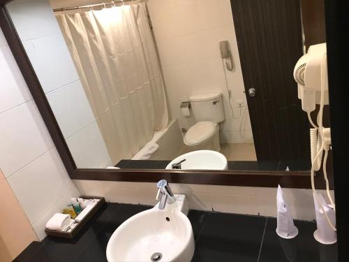 a bathroom with a sink and a toilet and a mirror at Rose View Hotel in Sylhet