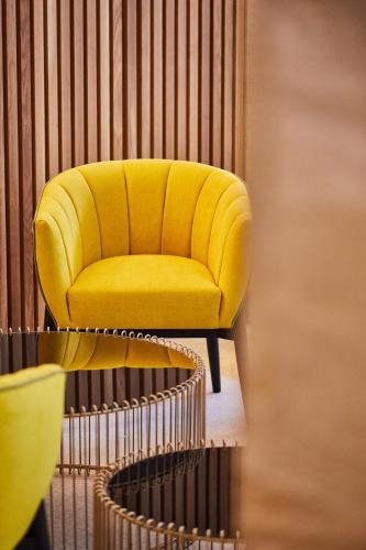 a yellow chair sitting on top of a staircase at Silken Reino de Aragón in Zaragoza