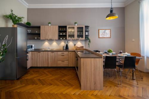 a kitchen with wooden cabinets and a table with chairs at Golden Key Apartments in Liberec