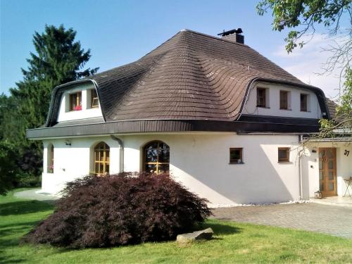 een groot wit huis met een bruin dak bij Ubytování Pod lázněmi Klimkovice in Klimkovice