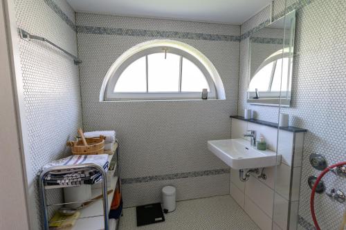 La salle de bains est pourvue d'un lavabo et d'une fenêtre. dans l'établissement Stadthaus Seeblick E75, à Friedrichshafen