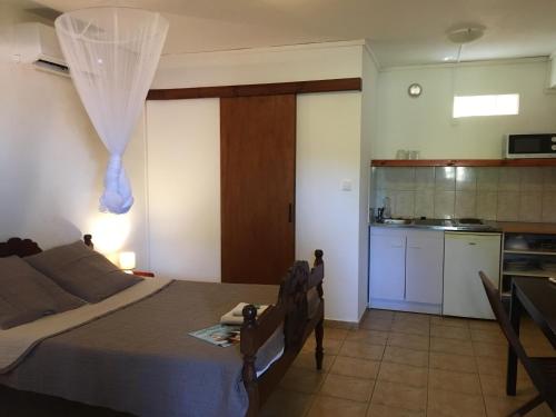 a bedroom with a large bed and a kitchen at La Residence in Mamoudzou