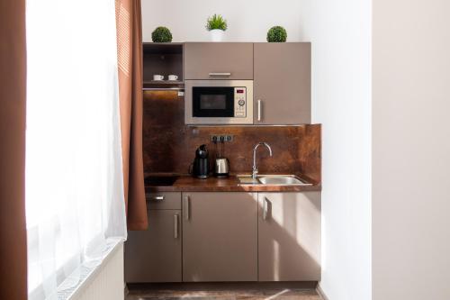 a kitchen with a sink and a microwave at Golden Key Apartments in Liberec