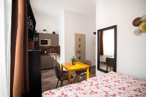 a room with a bed and a table and a mirror at Golden Key Apartments in Liberec