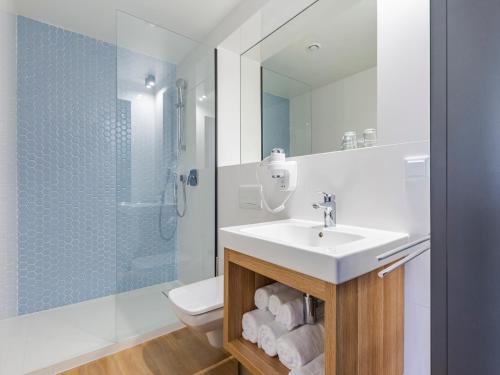 a bathroom with a sink and a toilet and a shower at Villa Verdi Pleasure & Spa in Łeba