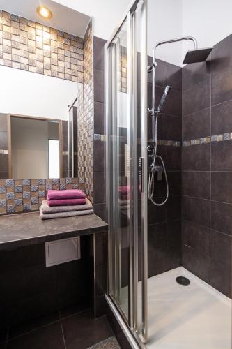 a bathroom with a glass shower and a sink at Golden Key Apartments in Liberec