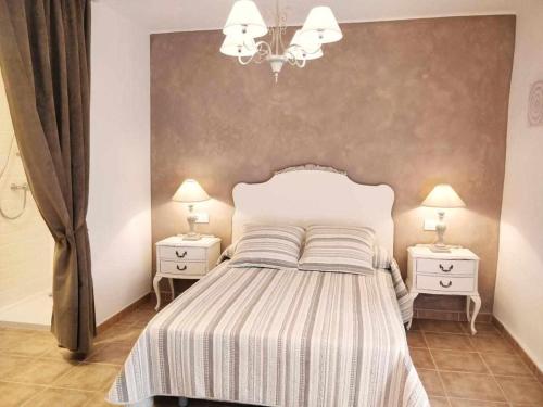1 dormitorio con 1 cama blanca y 2 mesitas de noche en Casa Rural els Esclopets, en Sanahuja