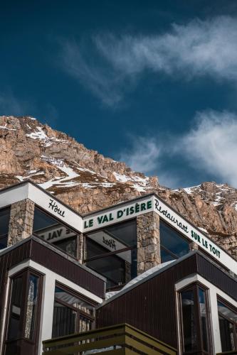 a building with a mountain in the background at Hotel & Spa Le Val d'Isère in Val dʼIsère