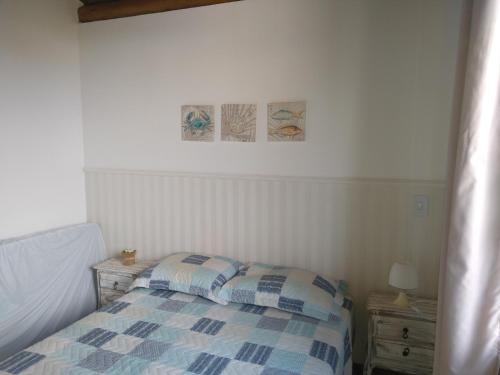 a bedroom with a bed and two pictures on the wall at Village Reserva das Ilhas - Itacimirim in Itacimirim