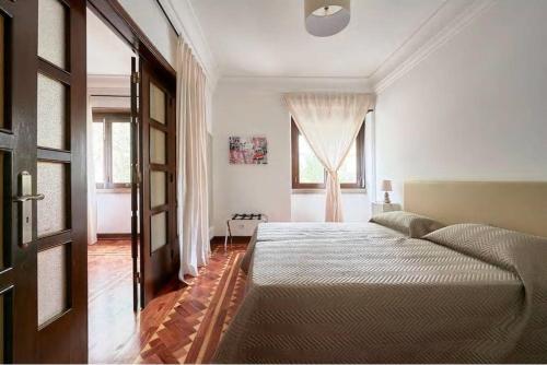 um quarto com uma cama grande e uma janela em Green Corner House em Lisboa