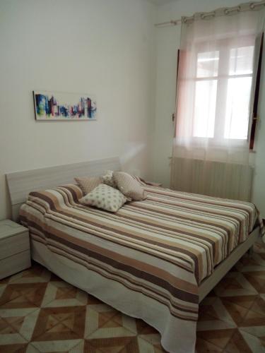 1 cama grande en un dormitorio con ventana en Appartamento a Mondello en Mondello