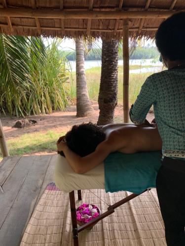 a woman is laying on a chair under a umbrella at Natura luxury red house in Ouidah