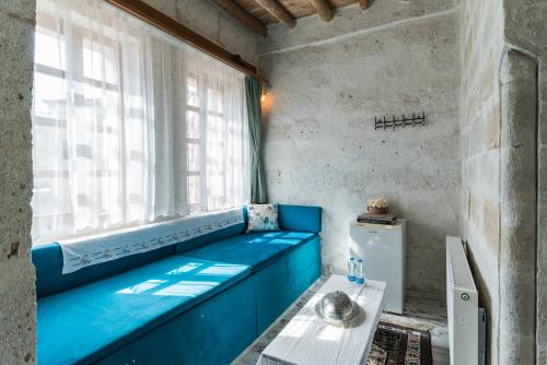a blue couch in a room with a window at Atilla's Cave Hotel in Nevsehir