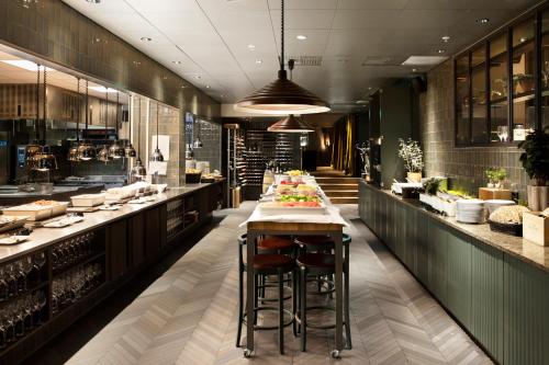 a restaurant with a long bar with stools in it at Elite Park Avenue Hotel in Gothenburg