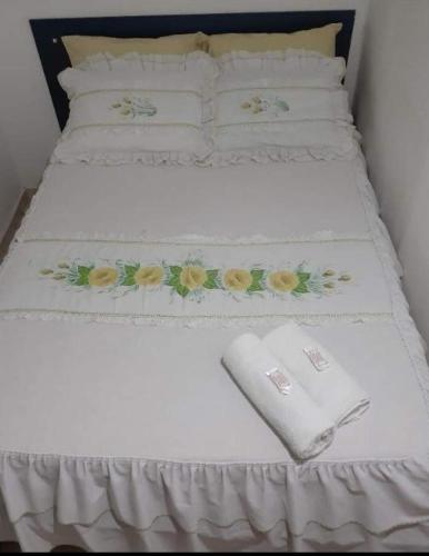 duas camas com lençóis brancos com flores em Hotel Hospedaria Albert em Cachoeiro de Itapemirim