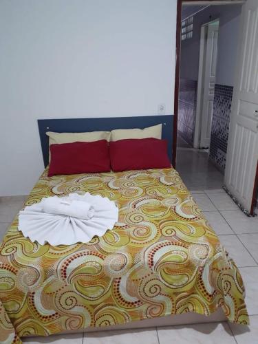 uma cama com duas toalhas em cima em Hotel Hospedaria Albert em Cachoeiro de Itapemirim